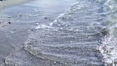 Calm Ocean Waves Gently Lapping the Shore at Midday in a Serene Beach Setting Stock Footage 306593020
