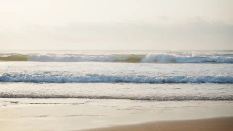 Calm ocean waves gently rolling onto a sandy beach during a beautiful golde.. Stock Footage 341426440