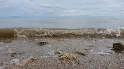 Calm ocean waves on muddy sandy beach Stock Footage 146312083