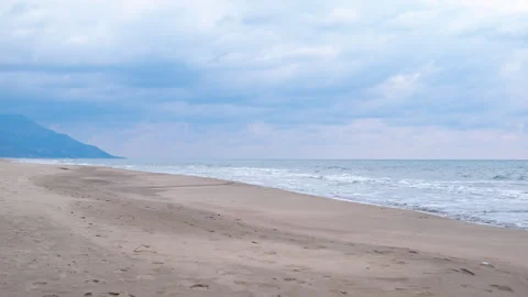 Calm ocean waves reaching sandy beach on cloudy day Stock Footage 321599246