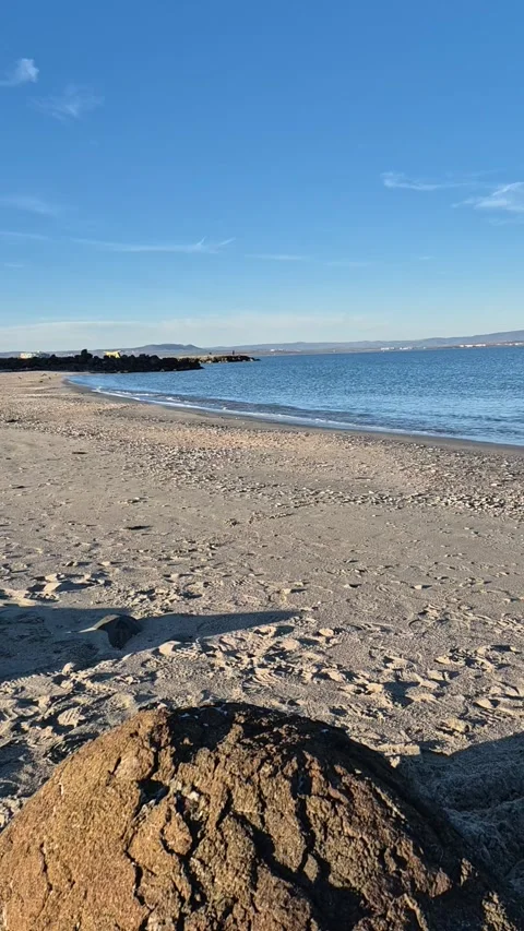 Calm ocean waves reaching the shore on a sunny day, vertical video Stock Footage 300305422