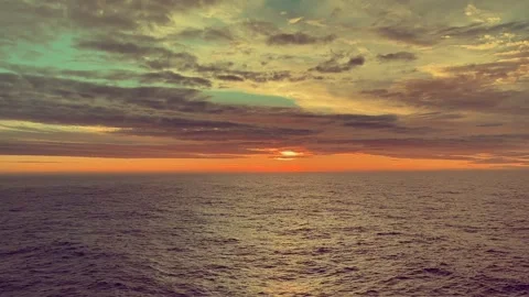 Calm Ocean Waves Reflecting Vibrant Red and Yellow Sunlight as the Sun Sets.. Stock Footage 338279785