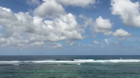 Calm ocean waves rolling over coral reef under a blue sky Stock Footage 335216106
