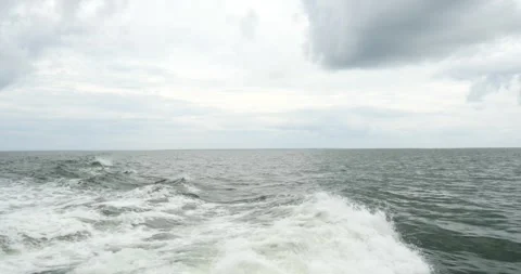 Calm ocean waves rolling under cloudy skies in the afternoon near the coast Stock Footage 281816820