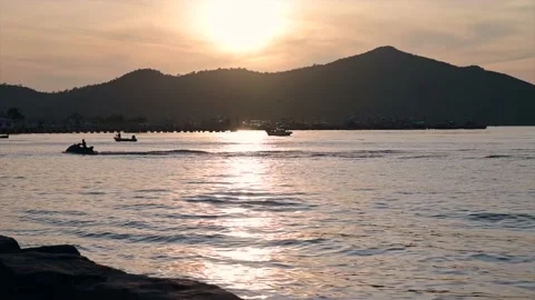 Calm ocean waves at sunset with mountain background Stockbeeldmateriaal 164731485