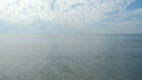 Calm ocean waves under cloudy sky in soft blue colors. Stock Footage 311457726