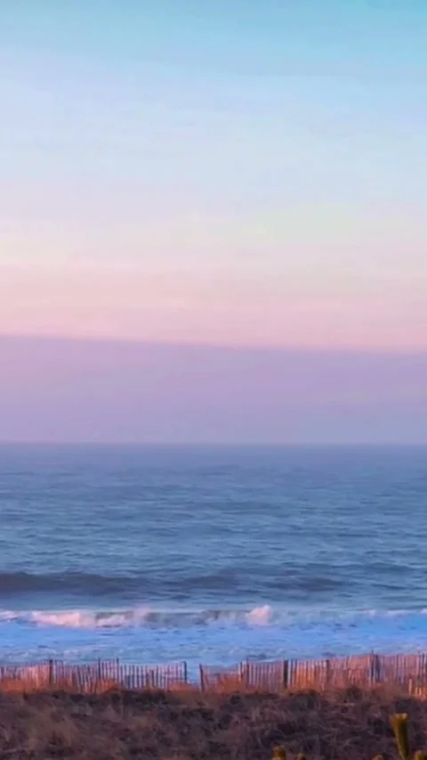 Calm Ocean Waves Under Soft Sunset Sky Video stock 331439931