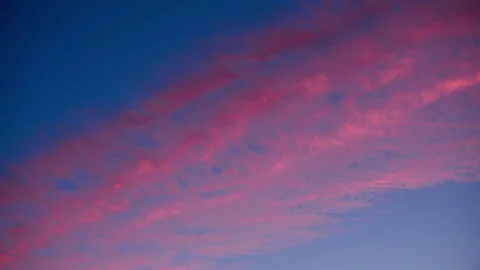 Calm pink clouds slowly float across the blue sky. Atmospheric phenomena. Stock Footage 204848794