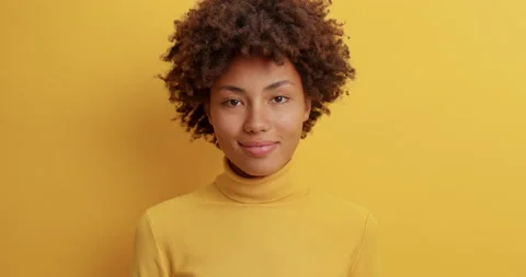 Calm pleasant looking young Afro American woman looks delightfully at camera Stock Footage 142329835