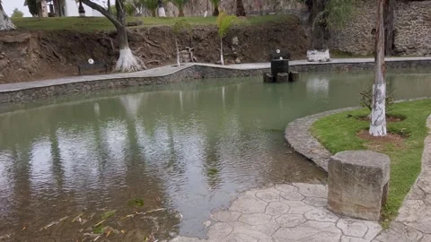Calm Pond Surrounded by Stone Pathways and Trees in Peaceful Mexico Park Vídeo Stock 336375043
