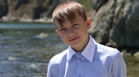 Calm positive boy smiling looking at the sea 库存影片 49922260