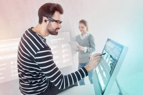 Calm programmer sitting on the table and working in his computer Stock-Fotos