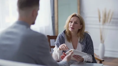 Calm psychologist explaining problem to client during therapy session Stock Footage 142376374