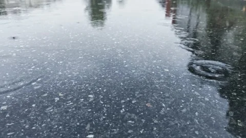 Calm rainy day drops falling into the puddle make small bubbles. Video stock 161152426
