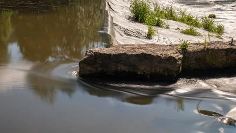 Calm Reflective River Surface Below a Stone Weir (Long Exposure) Stock Photos