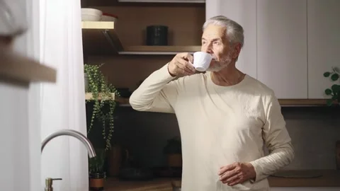 Calm relaxed senior gray haired man with cup of hot coffee or tea enjoying Stock Footage 253513700
