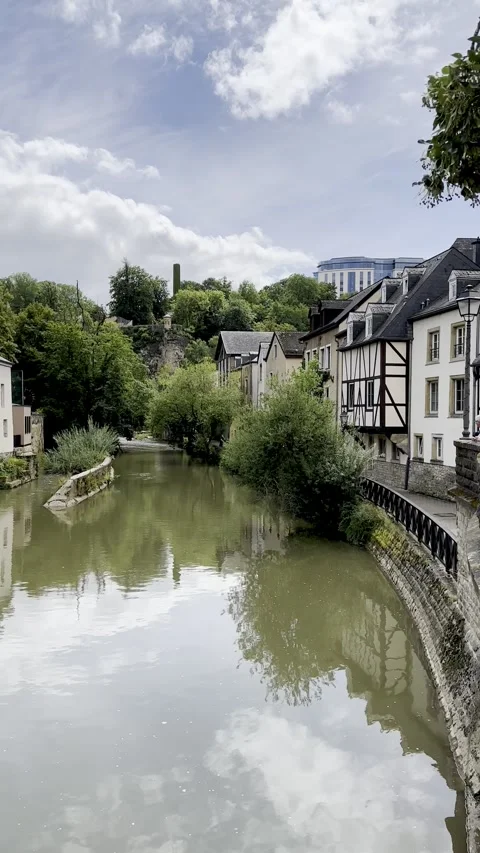 Calm river canal running alongside traditional timber-framed European house. Video stock 345414035