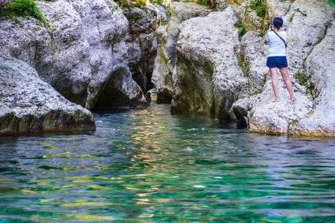 Calm river with clear water between white rocks. Tourist takes a Foto stock