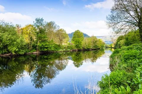 Calm River Conwy Reflection with Lush Green Trees and Summer Sky, Llanrwst,.. Stock Photos