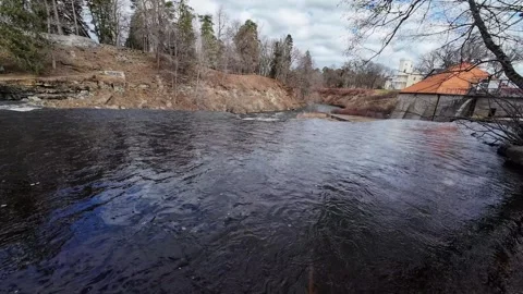 Calm River Current Passing Historic Mill Building Under Cloudy Sky Stock Footage 337535788