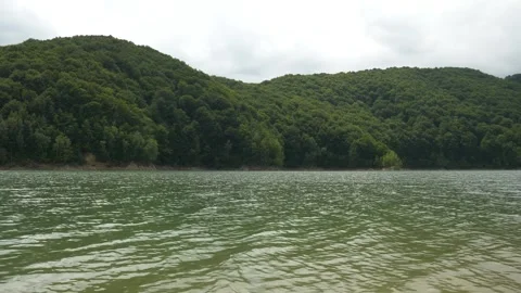 Calm River Flow with Forested Hills in the Background Stock Footage 314694238