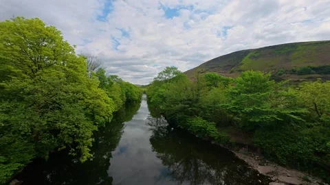 Calm River Flowing Through Lush Green Woodland and Hills in Wales Vidéo 339990128