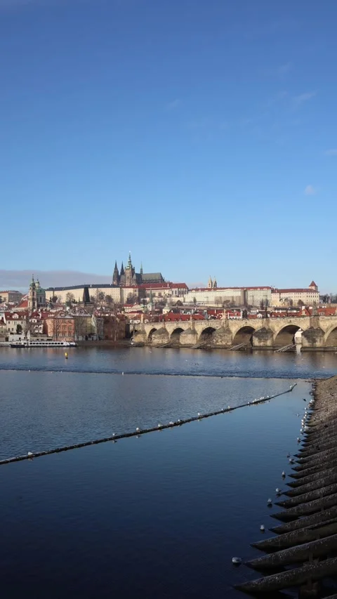Calm river flowing through old cinematic city with historic bridge and red roofs Stock Footage 326194570