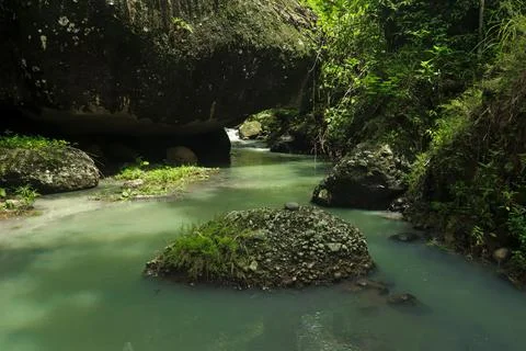 Calm River Flowing Through Rocks in a Tropical Forest Stock Photos