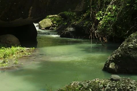 Calm River Flowing Through Rocks in a Tropical Forest Stock Photos