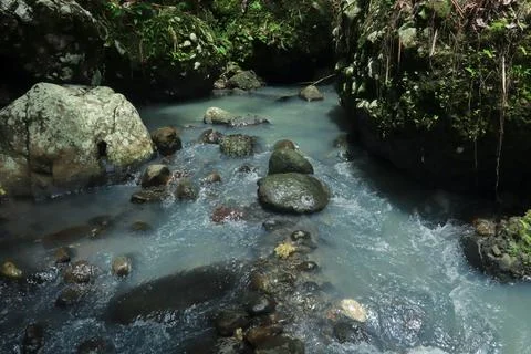 Calm River Flowing Through Rocks in a Tropical Forest Stock Photos