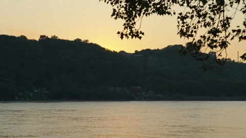 The calm river flows gently past dark hills after sunset Stock Footage 339630541
