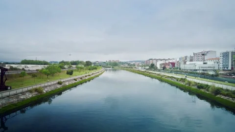 Calm river flows through an urban park in Asturias, Spain Видео 336491961