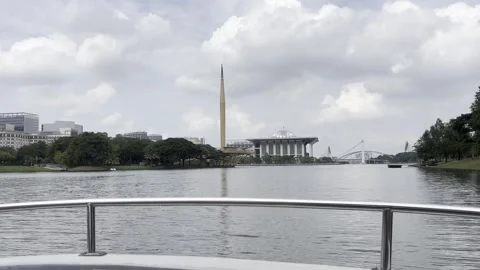 Calm river flows under bright, partly cloudy skies Stock Footage 340034308