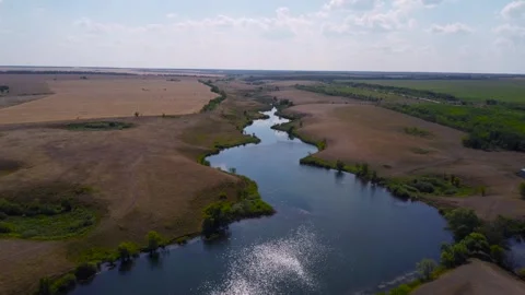 A calm river gliding through green fields and a lush landscape, viewed from Stock Footage 283609805