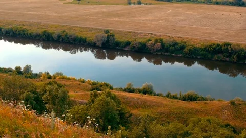 Calm river with mirror surface and reflecting sky among natural fields and hills Stock Footage 91627905