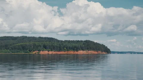 Calm river with rocky coast covered with forest during sunny summer day Stock Footage 338145694