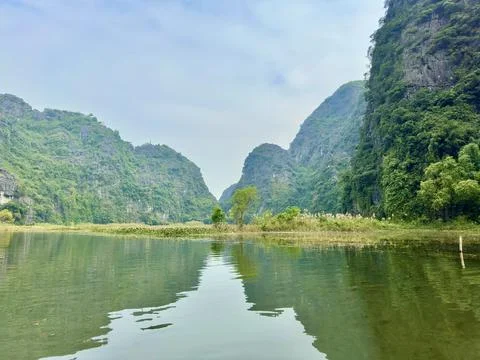 The calm river surface acting as a mirror reflecting the sky and distant Foto stock