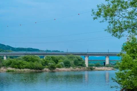 Calm river with train on bridge Stock Photos