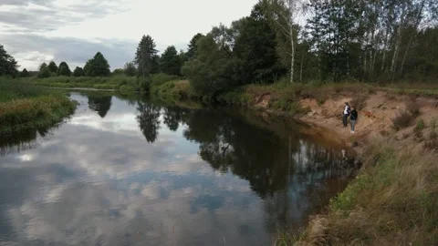 Calm rural river, two people fishing from the bank Stock Footage 338133829