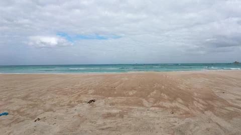 Calm sandy beach under cloudy sky Stock Photos
