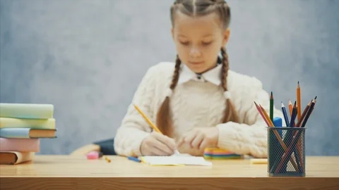 Calm schoolchild is erasing something in her copybook. Stock Footage 113070455