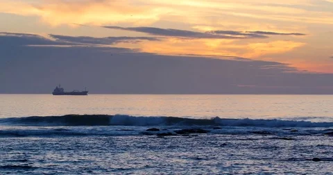 Calm sea during sunset with a cargo ship on the horizon 動画素材 70211740