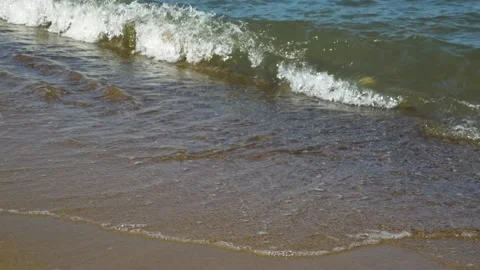 Calm sea with small waves, sandy beach, no people, close-up, sunny day Stock Footage 165730131