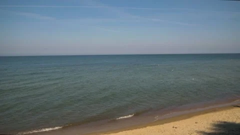 Calm sea with small waves, sandy beach, no people, general plan, day, 4K video Stock Footage 165730140