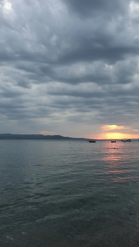 Calm sea sunset with dramatic clouds and distant boats Stock Footage 341318234