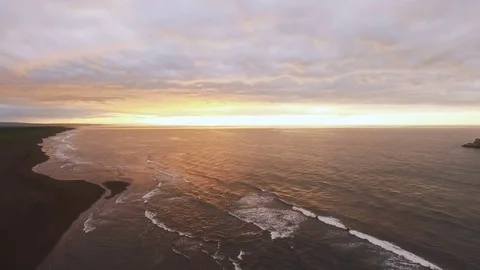 Calm sea at sunset. Mountain stream flows into the ocean. The orange sun is Stock Footage 72766875