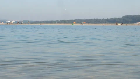 Calm Sea Water Distant Beach Umbrellas and People on Sunny Summer Vacation Stock-Footage 338400444
