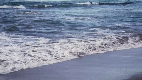 Calm sea waves breaking gently on the shore, captured from a static perspective Stock Footage 313285753