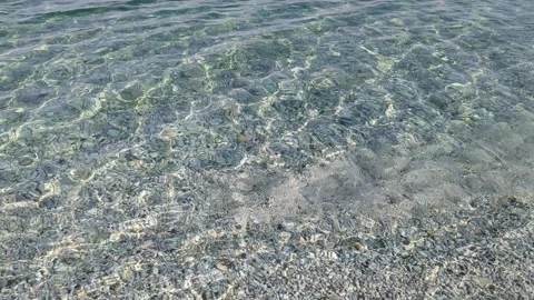 Calm sea waves crash on a pebble beach. Transparent sea water on the beach Stock Footage 249326092