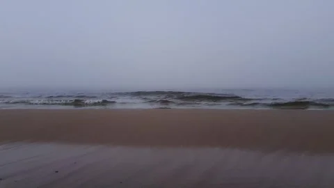Calm sea waves on empty sand beach at foggy morning 4K Stock Footage 337817793